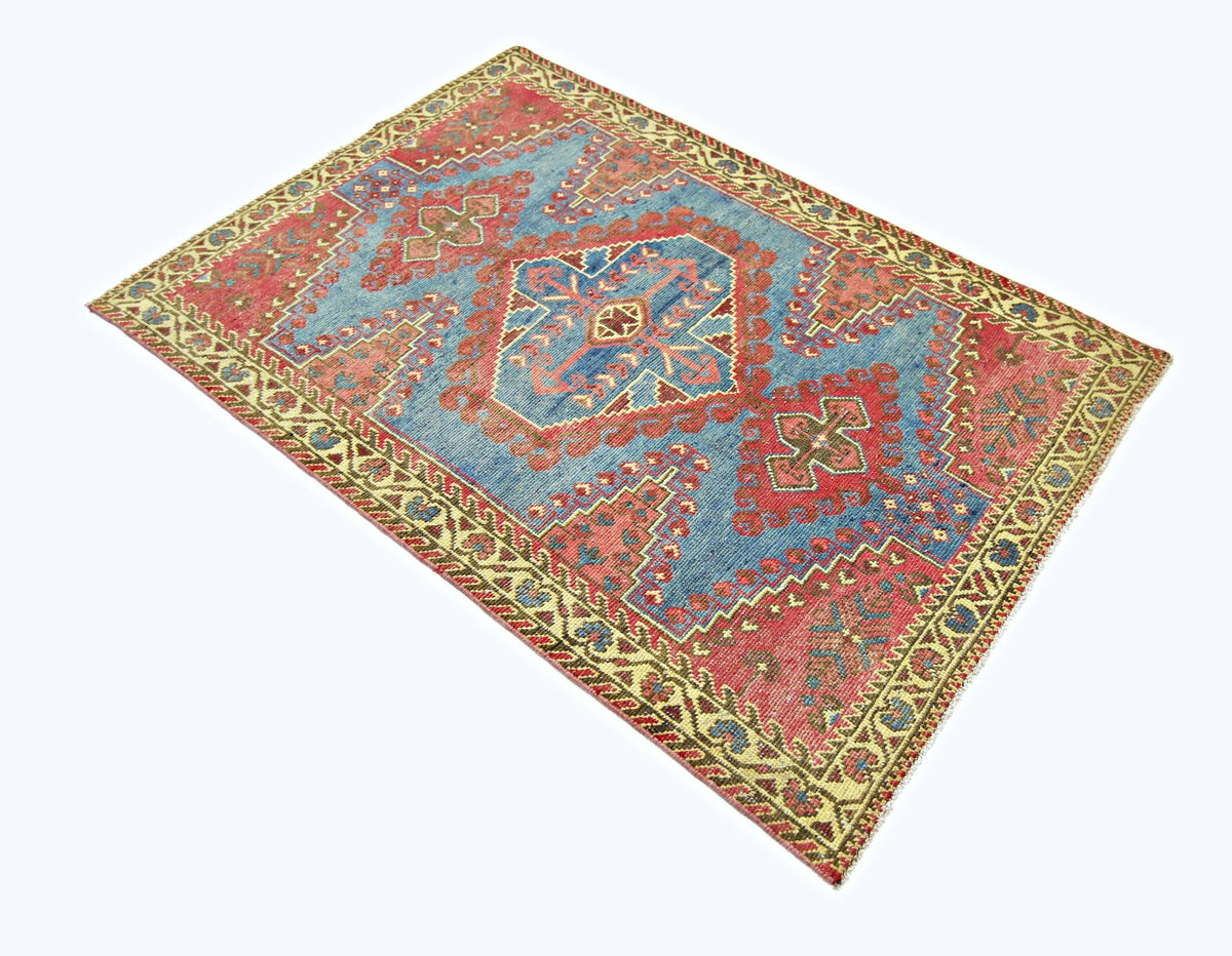 A vintage handmade Persian Wiss rug featuring a geometric pattern in blue, red, and cream tones.