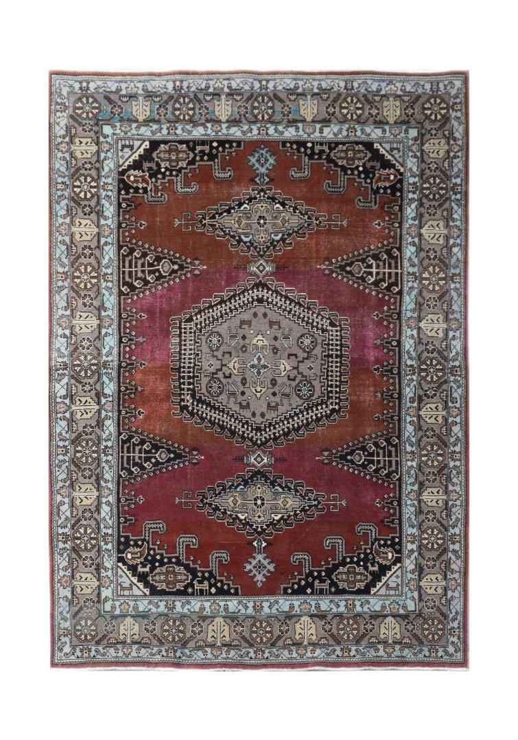 A handmade vintage Persian Wiss rug featuring a central medallion on a deep red and grey field.