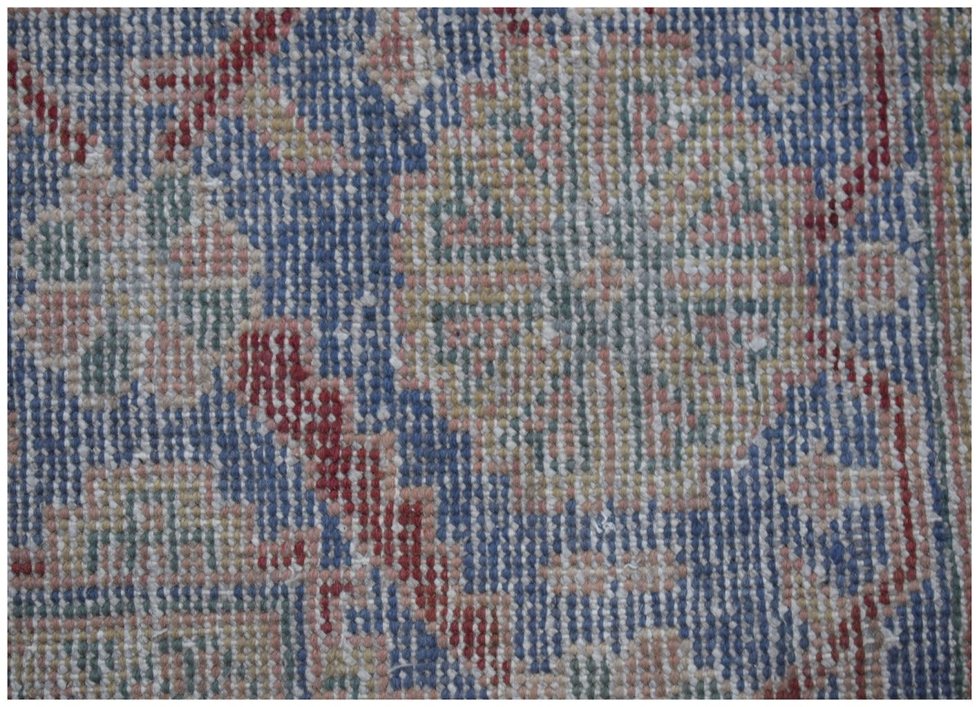 A close-up view of a vintage Persian rug featuring intricate floral patterns in blue and red.