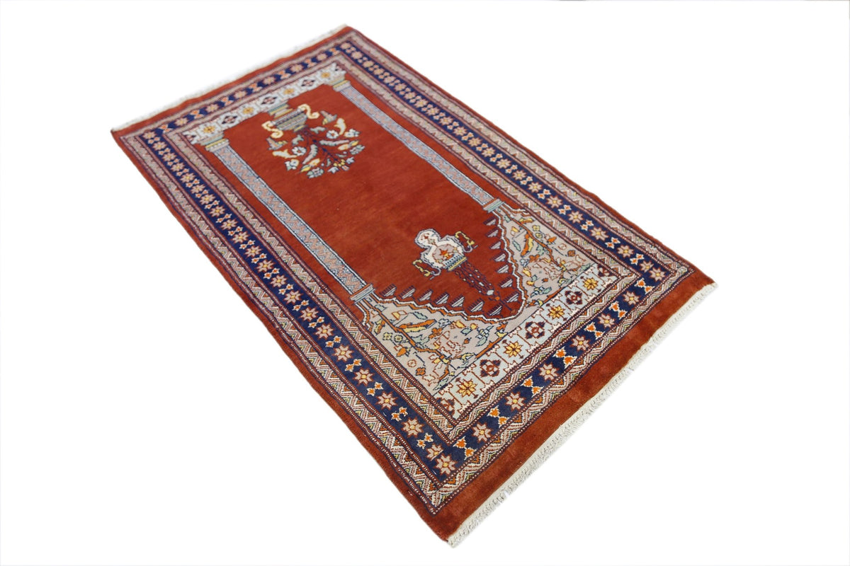 Hand-knotted Pakistani wool rug in deep red with intricate floral motifs, a decorative mihrab design, and white fringe.