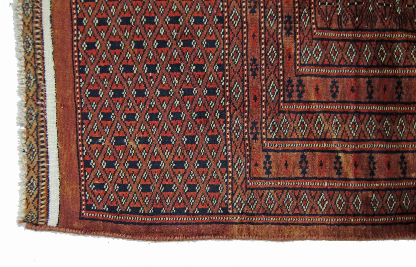A vintage Pakistani Princess Bokhara rug featuring a geometric diamond pattern in red and black.