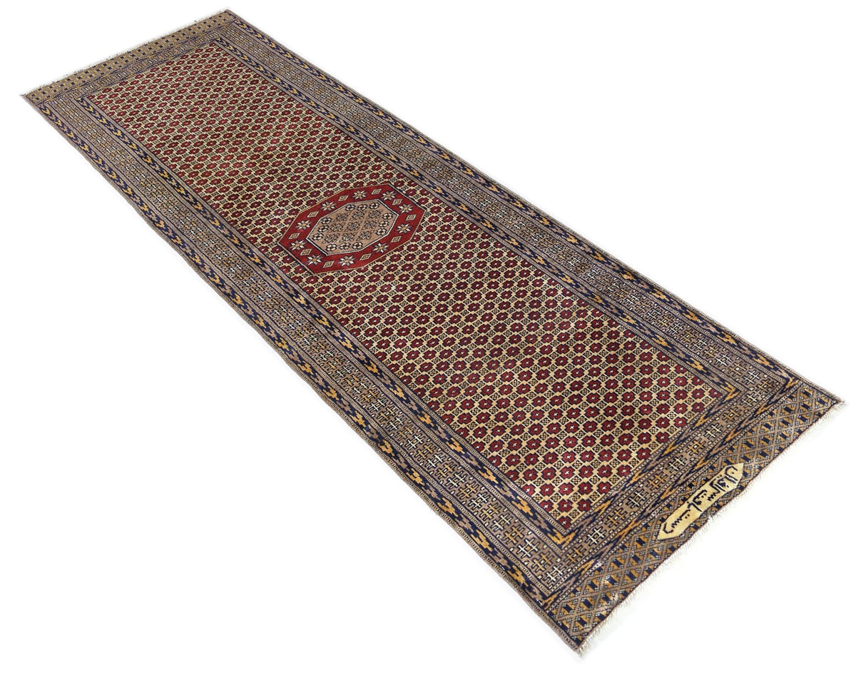 Vintage Princess Bokhara runner featuring a red field with repeating geometric guls, intricate blue borders, and fringe.
