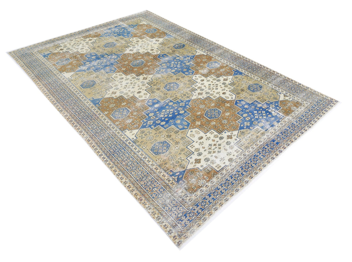 Vintage Turkish Anatolian rug featuring a geometric blue, tan, and cream medallion pattern with a detailed border.