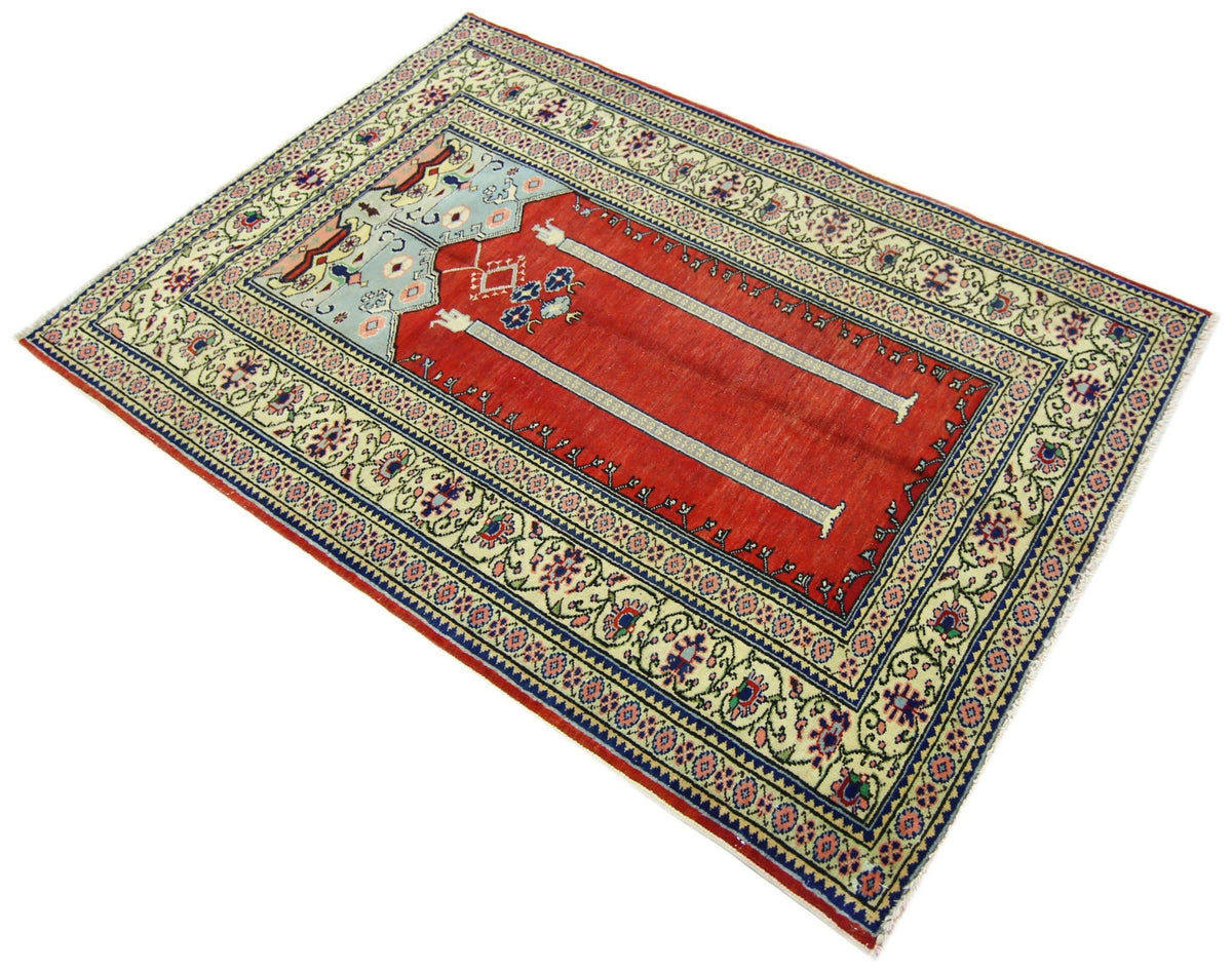 Vintage Turkish Kayseri prayer rug with a red field, light blue niche, and intricate floral borders on a cream background.