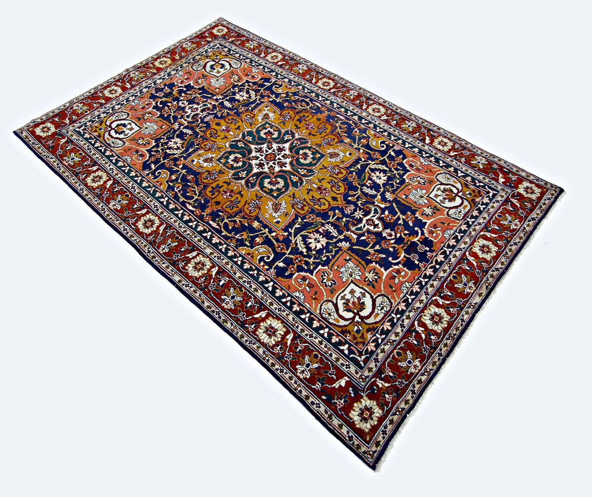 Vintage Turkish Kayseri rug featuring a central floral medallion, scrolling vines, and a deep blue, red, and gold palette.