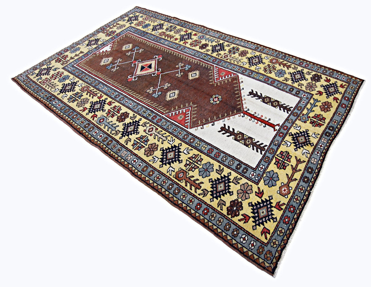 Vintage Kayseri rug featuring a central brown prayer niche, floral motifs, and a cream border with intricate geometric patterns.