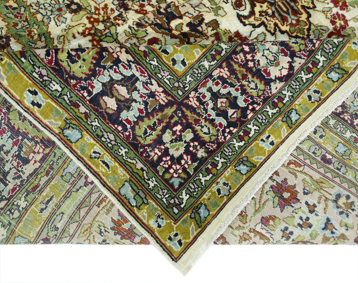 A vintage Turkish Kayseri rug featuring intricate floral patterns in green, red, and cream tones.