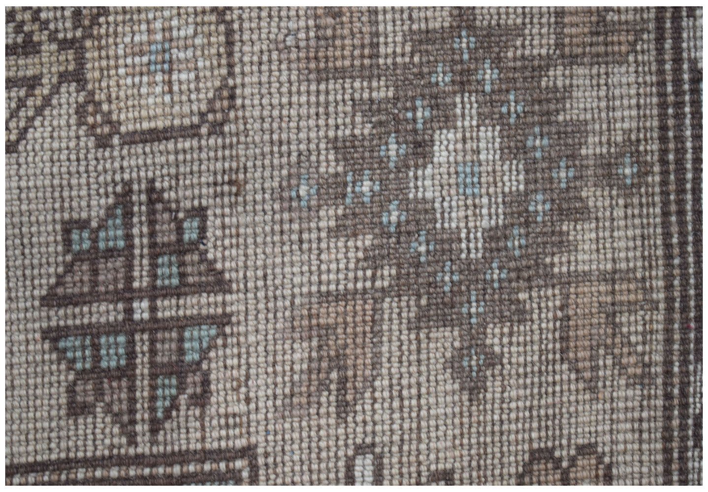 A close-up of a vintage Turkish Milas rug featuring a traditional geometric pattern in wool.