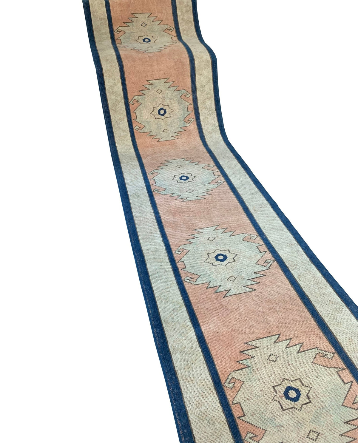 Vintage Turkish Oushak runner featuring soft pink, cream, and blue geometric medallions in a long, narrow composition.
