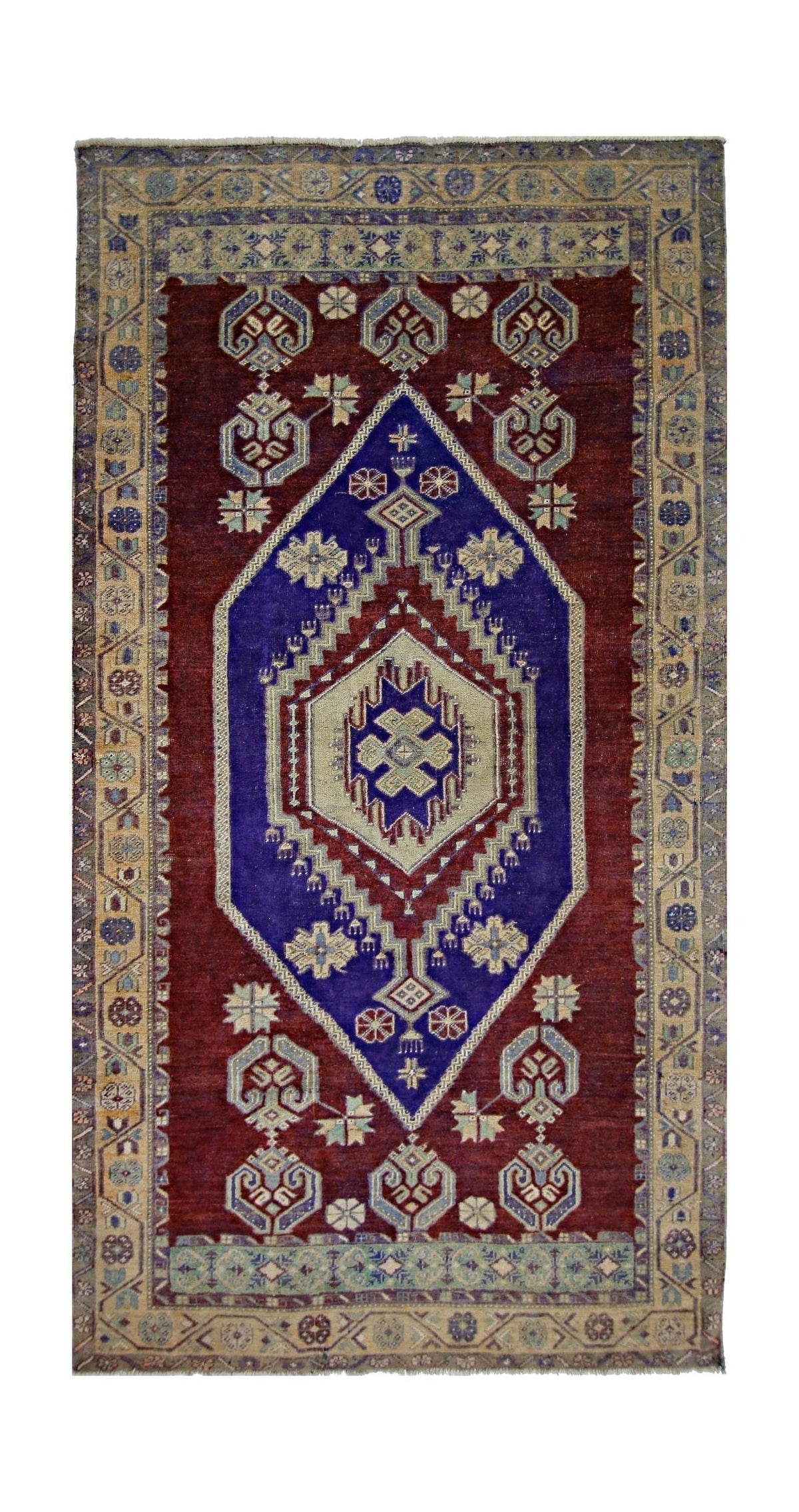 Vintage Turkish Taspinar rug featuring a deep red field, blue stepped medallion, and intricate geometric floral borders.