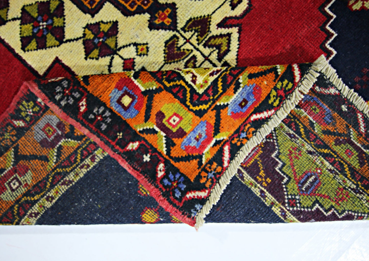 A vintage handmade Turkish Taspinar rug featuring intricate geometric patterns in vibrant colors.