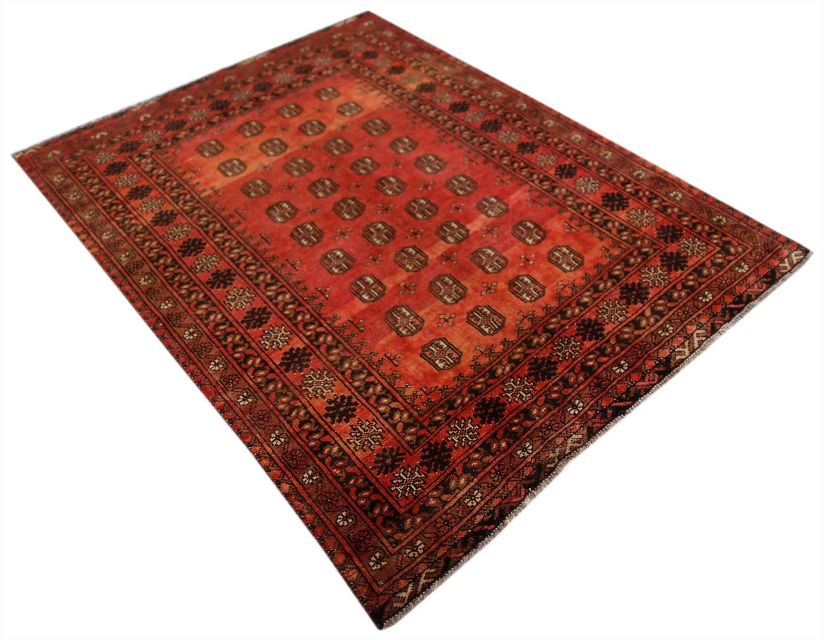 A vintage handwoven Afghan Turkmen rug featuring a repeating geometric pattern in shades of red.