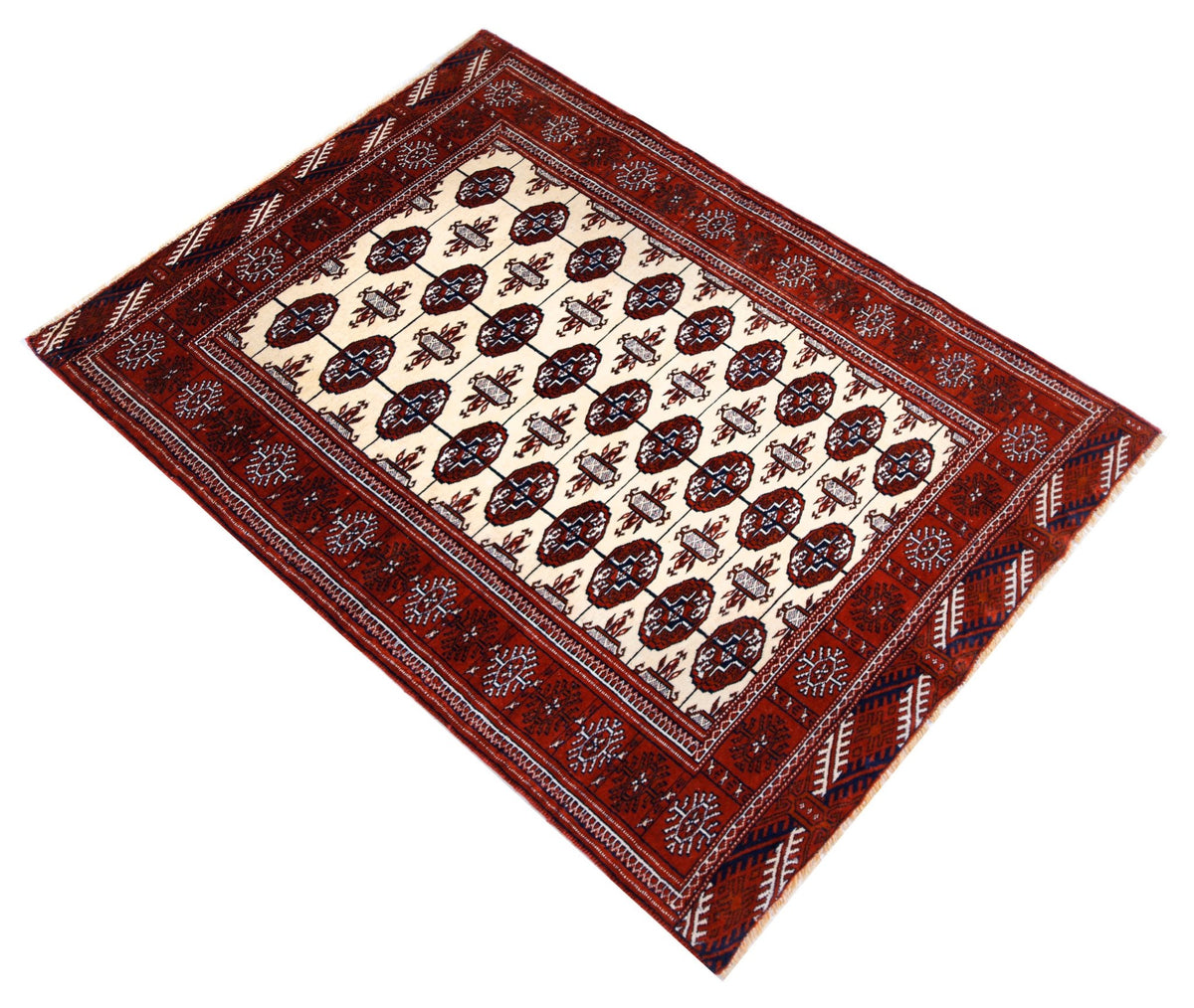 Vintage Turkmen Tekke rug with repeating octagonal guls in deep crimson, ivory, and indigo blue on a white field.