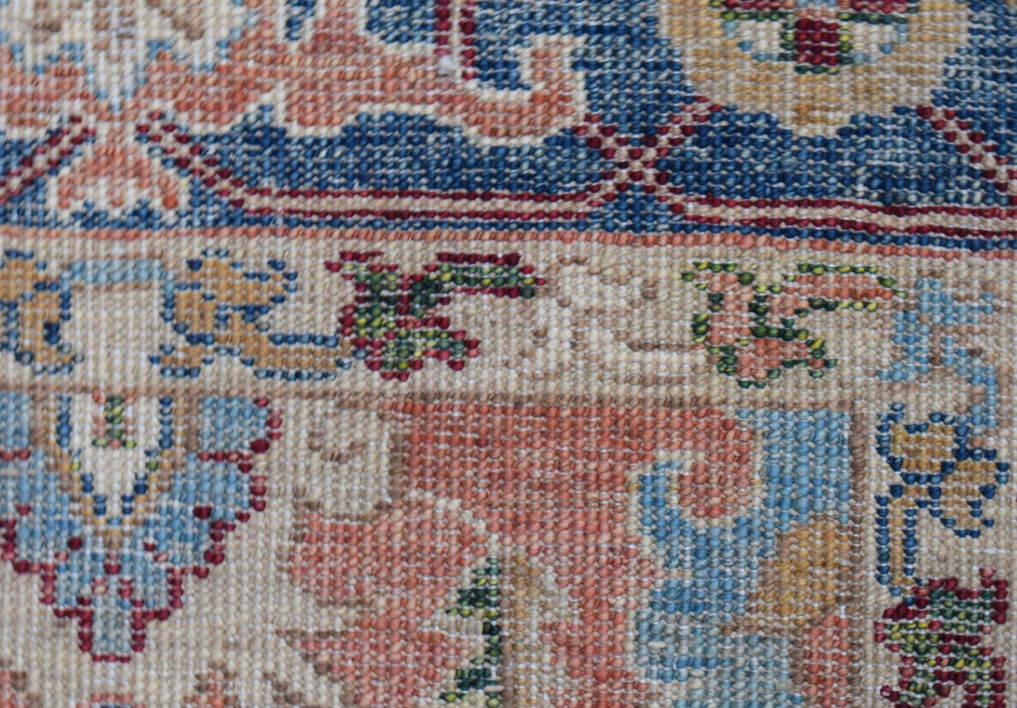 A close-up of a hand-knotted Afghan Chobi runner featuring intricate floral patterns in wool.