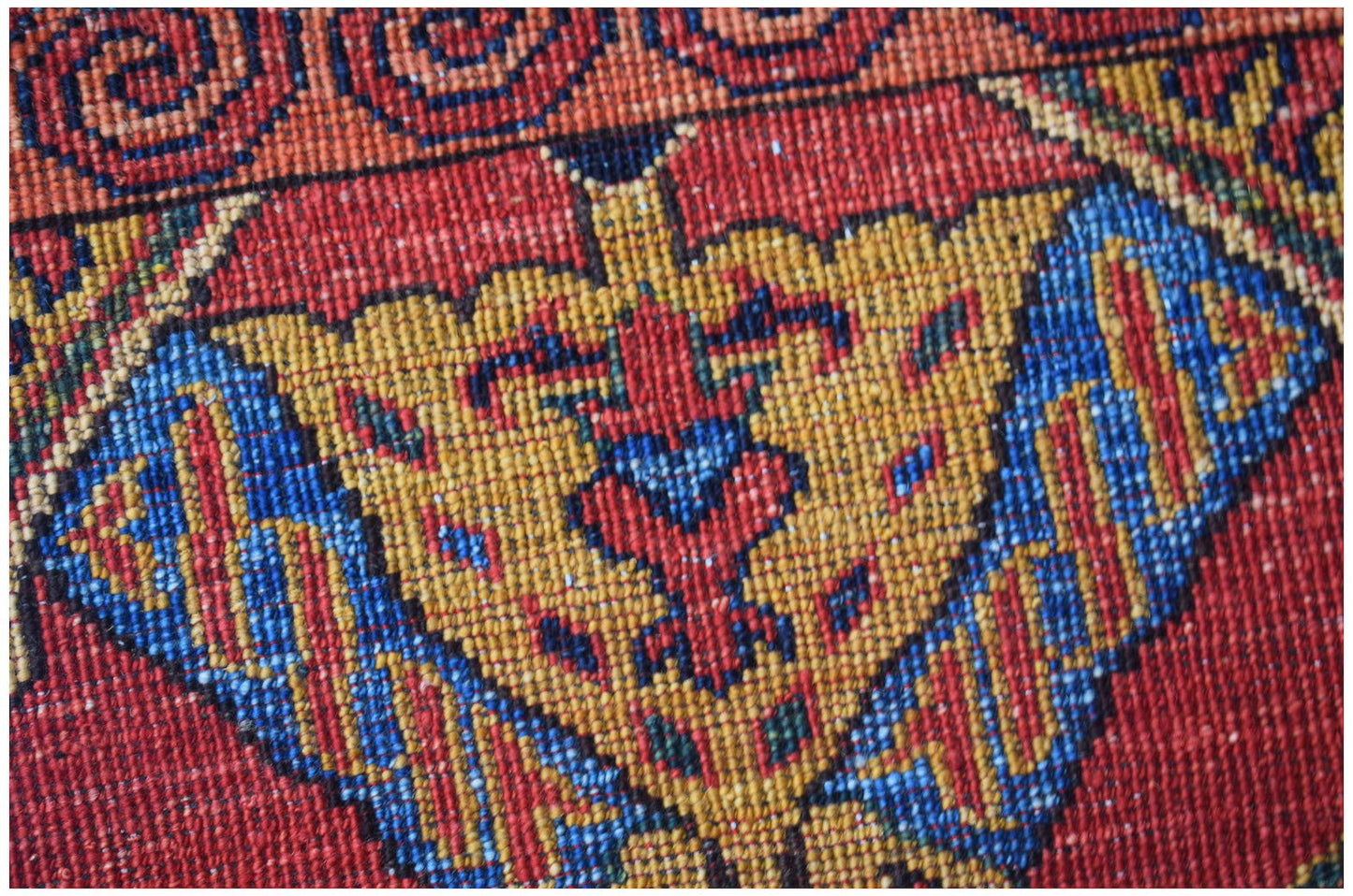 A close-up of a handwoven Afghan Chobi runner featuring intricate geometric patterns in wool.
