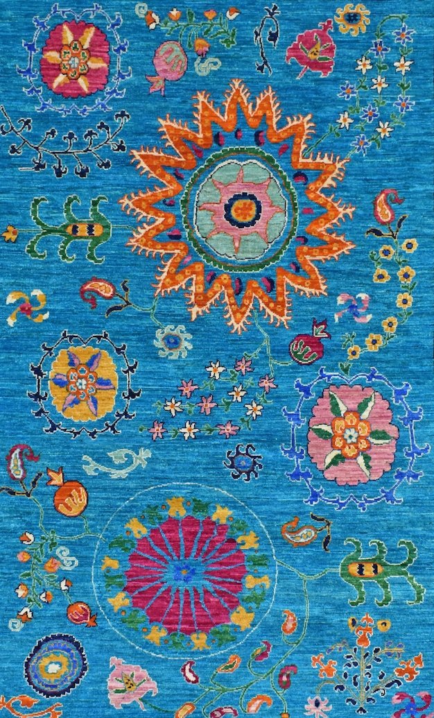 A handwoven Afghan Chobi rug featuring vibrant floral and geometric motifs on a blue background.