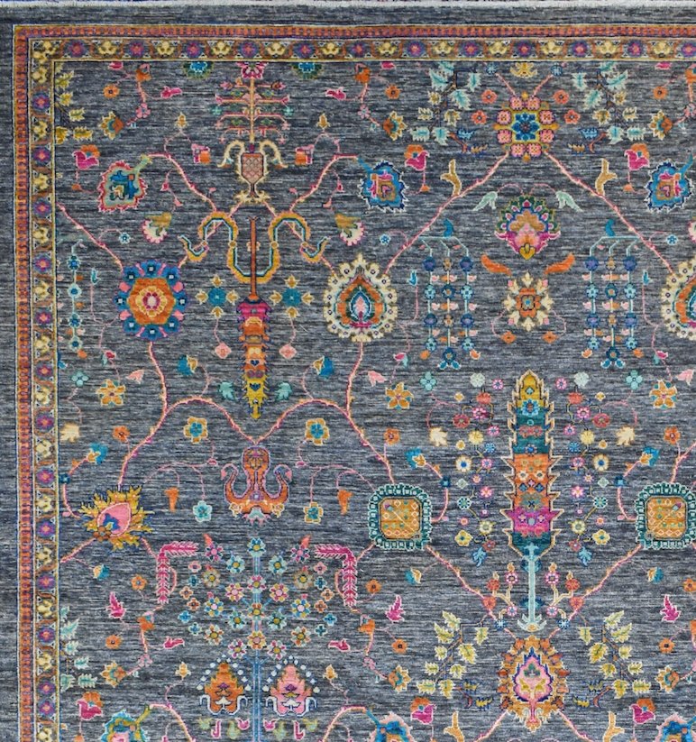 A handwoven Afghan Chobi rug featuring a dark grey field with intricate, colorful floral patterns.