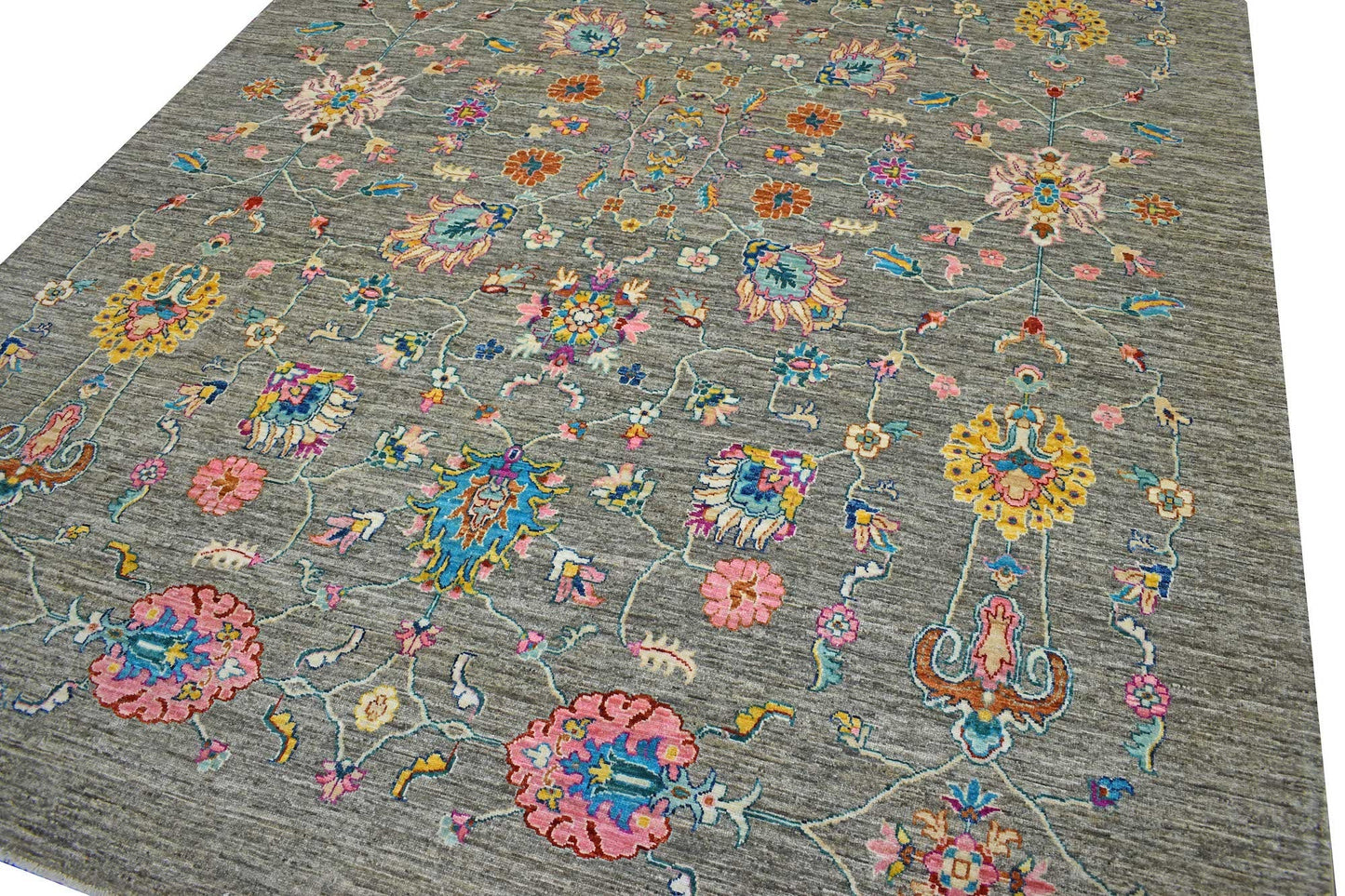 A handmade Afghan Chobi rug featuring a grey field with colorful floral and vine patterns.
