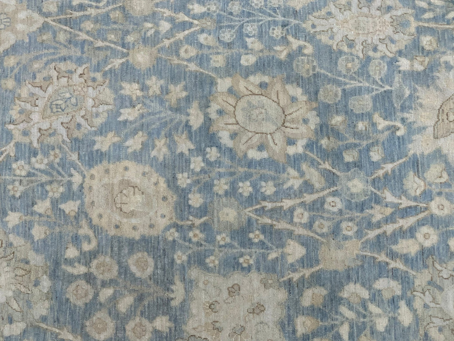 An Afghan Balkh rug featuring a traditional floral pattern in shades of blue and beige.