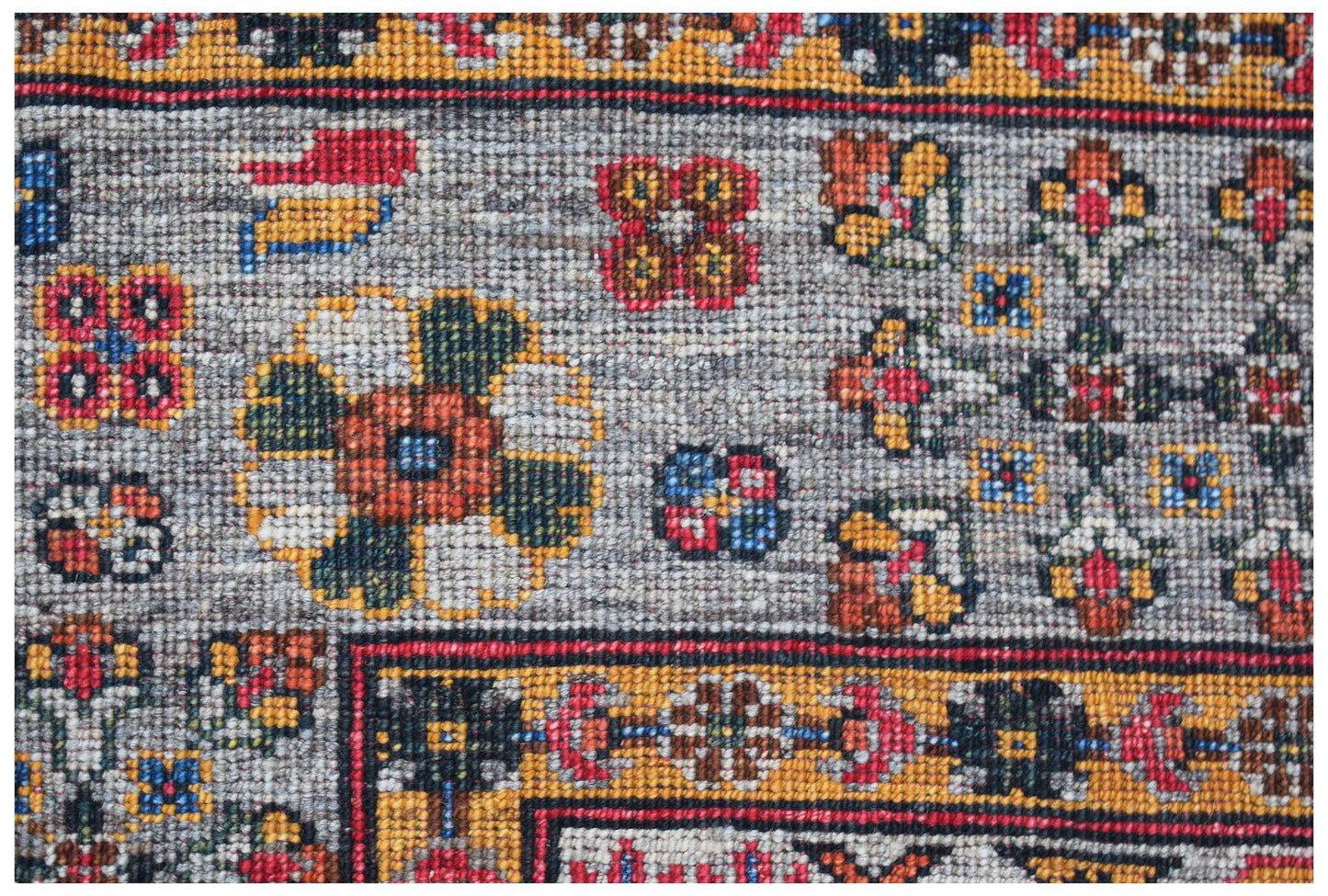 A close-up of an Afghan Chobi rug featuring intricate floral patterns in earthy tones.