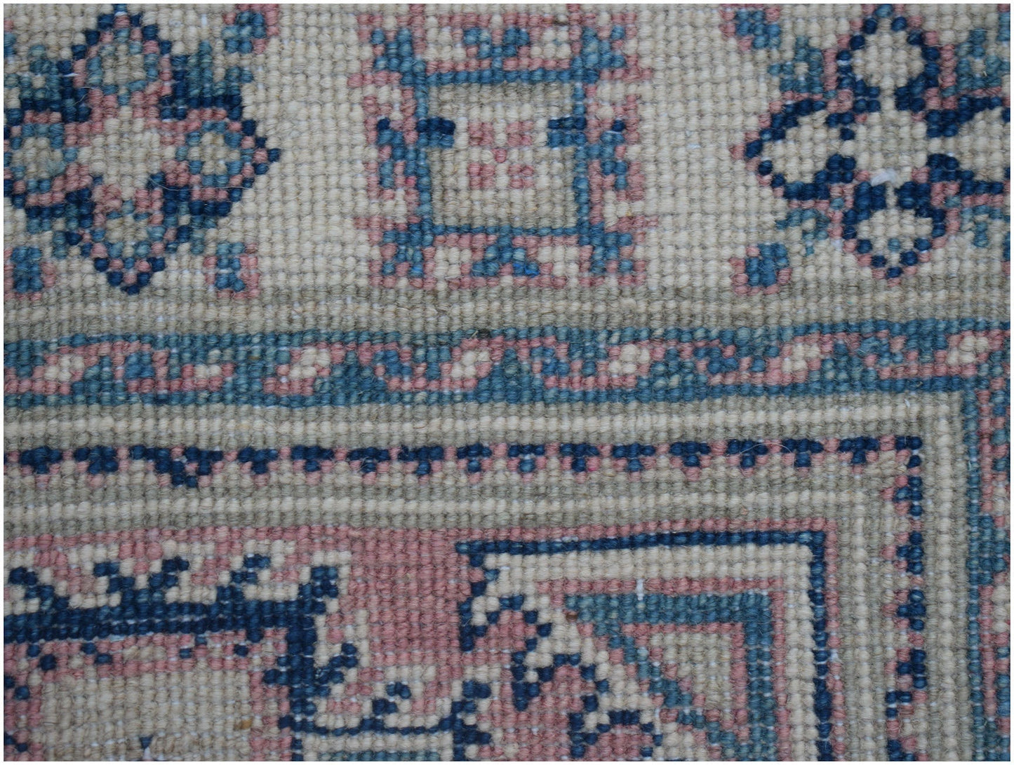 A handmade Afghan Kazakh runner featuring traditional geometric motifs in blue, pink, and cream.