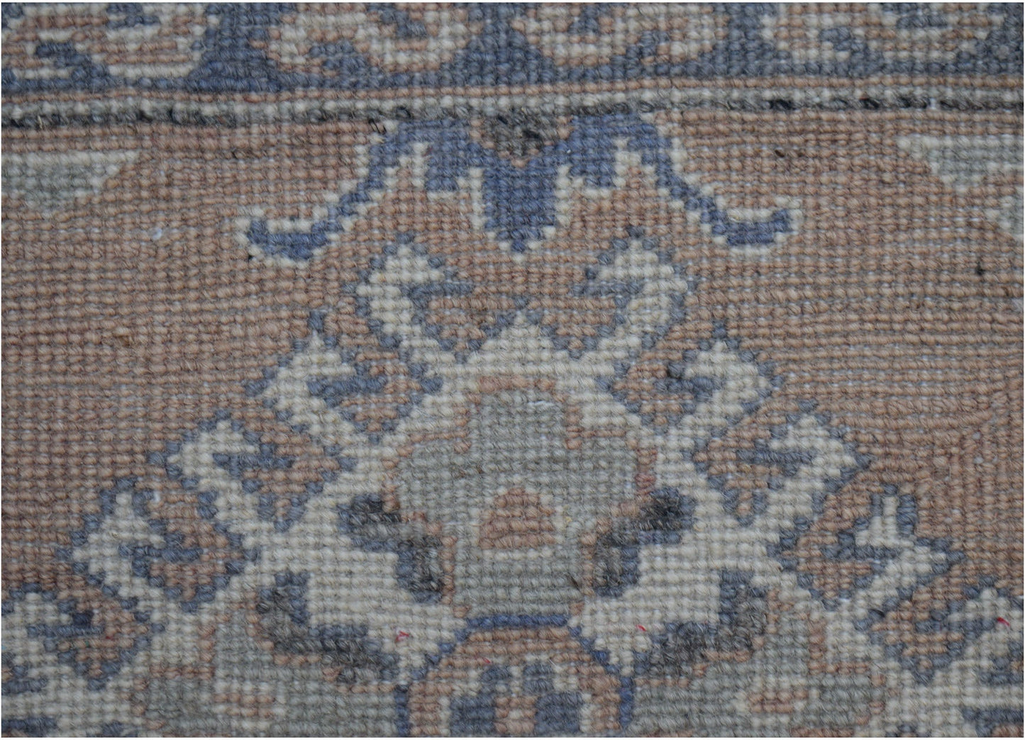 A close-up of an Afghan Kazakh runner featuring traditional geometric motifs in wool.