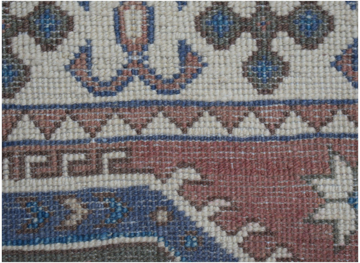 A close-up of an Afghan Kazakh runner featuring traditional geometric patterns in wool.