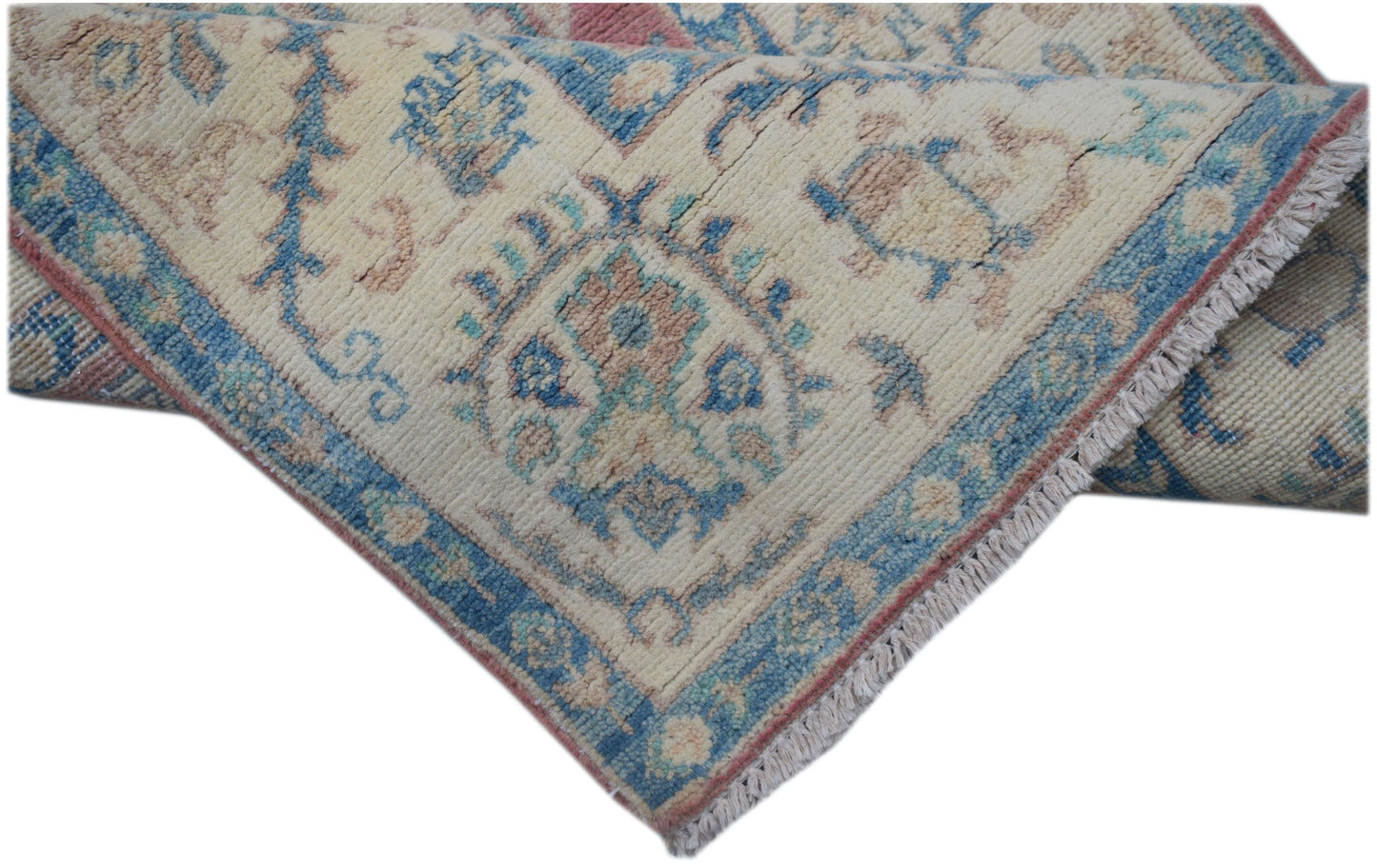 A handmade Afghan Kazakh runner featuring traditional blue and pink geometric motifs on wool.