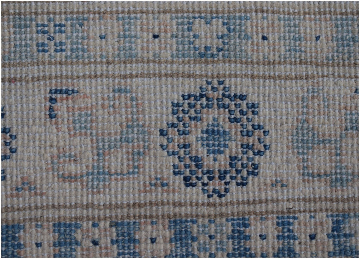 A handmade Afghan Kazakh runner featuring a geometric floral pattern in blue and beige tones.