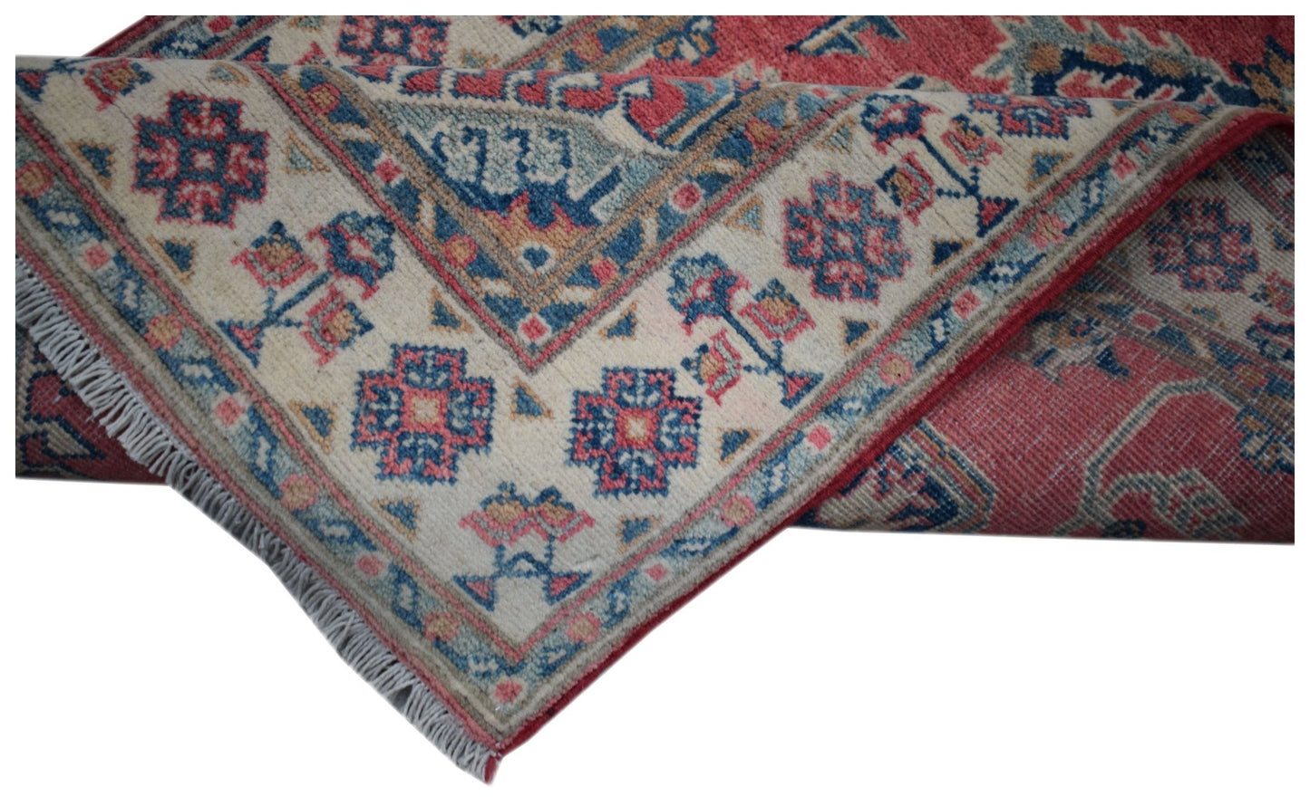 An Afghan Kazakh runner rug featuring traditional geometric motifs in red, blue, and cream.