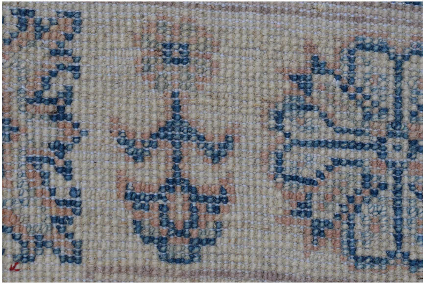 A close-up of an Afghan Kazakh rug featuring traditional blue and peach geometric floral patterns.