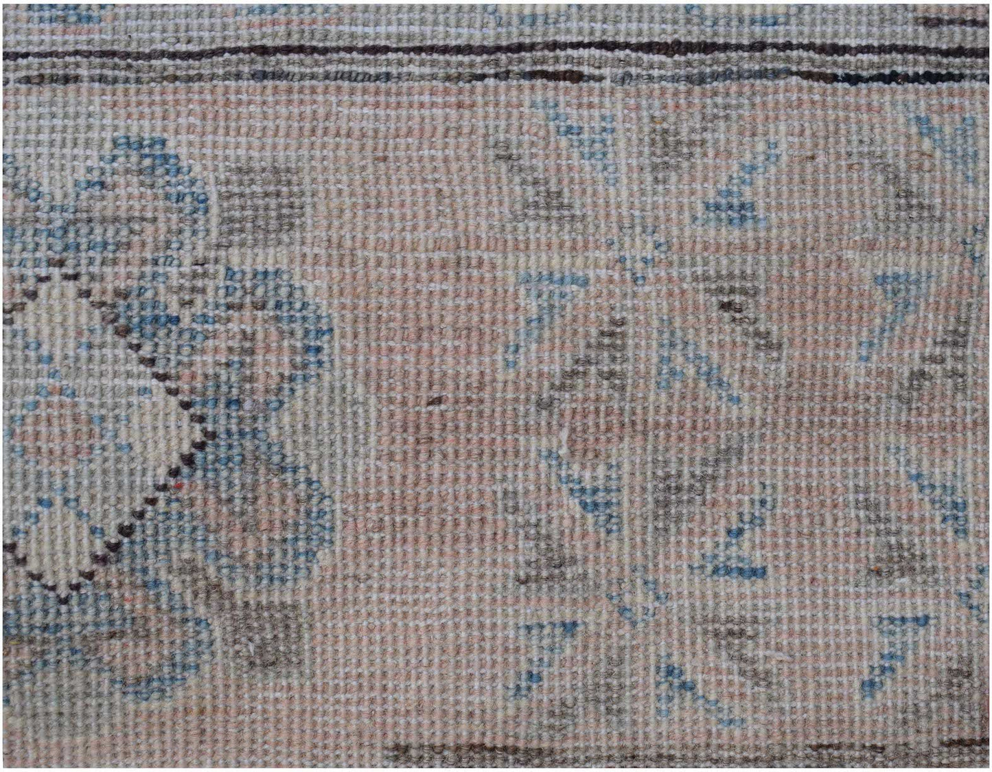 A handmade Afghan Kazakh rug featuring traditional floral patterns in muted blue and brown tones.