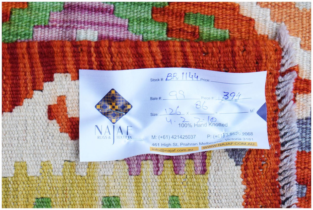 A close-up of a handwoven Afghan Maimana Kilim featuring vibrant geometric patterns in wool.