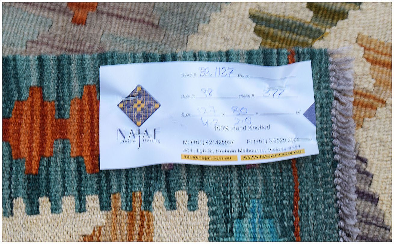 A handwoven Afghan Maimana kilim featuring a geometric pattern in teal, orange, and cream tones.