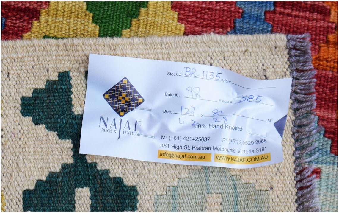 A handwoven Afghan Maimana Kilim featuring a colorful geometric pattern and flatweave texture.