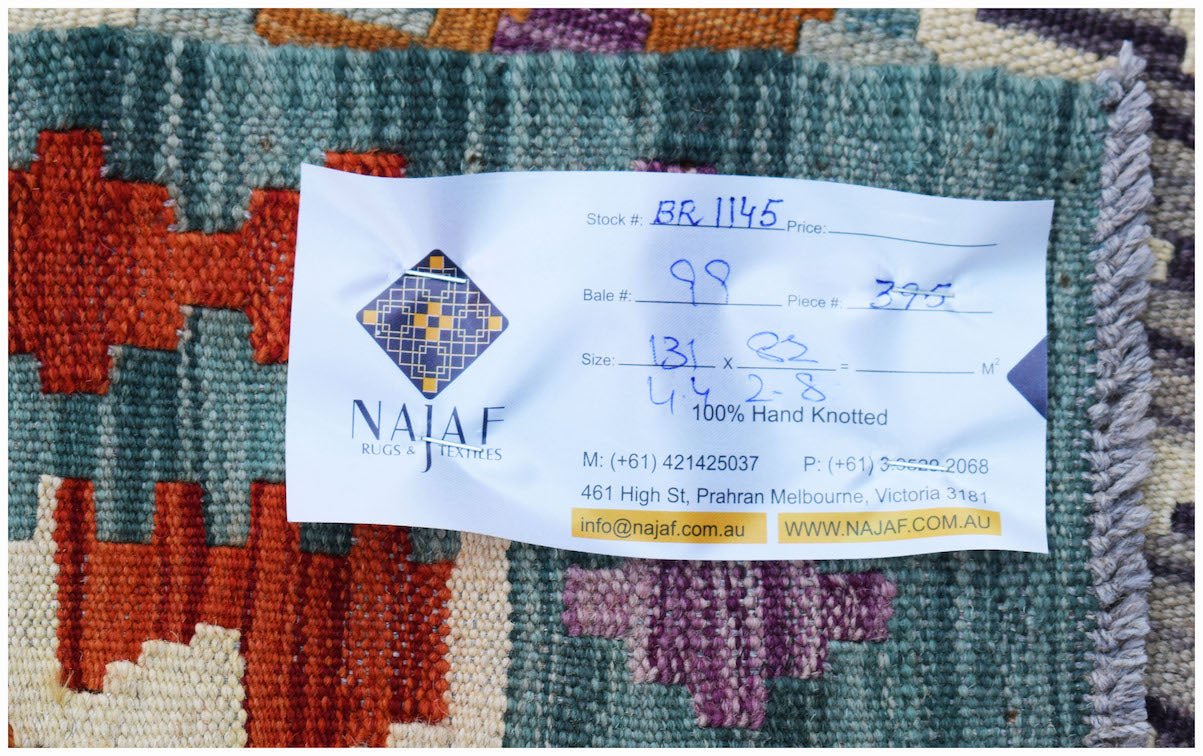 A handwoven Afghan Maimana kilim featuring a geometric pattern in orange, teal, and purple.