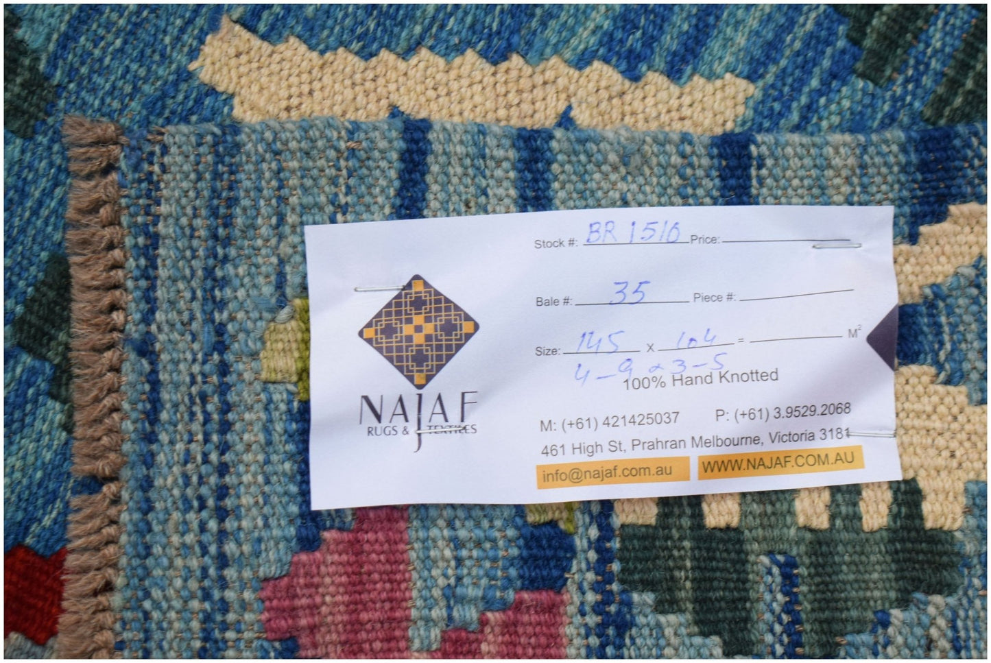 A handwoven Afghan Maimana Kilim featuring a geometric pattern in blue, cream, and pink tones.