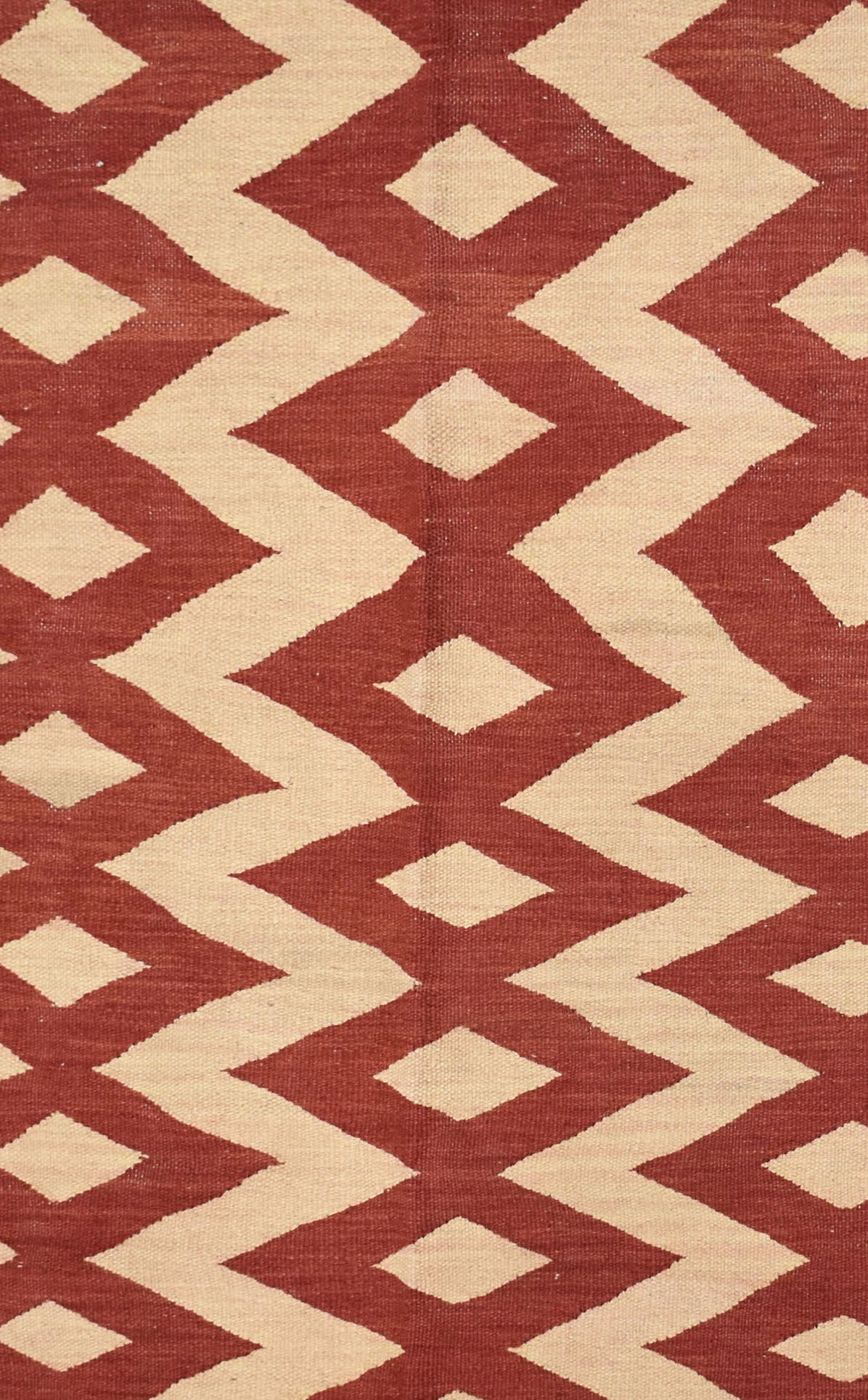 Handmade Afghan Maimana kilim rug featuring a repeating geometric diamond pattern in red and cream.