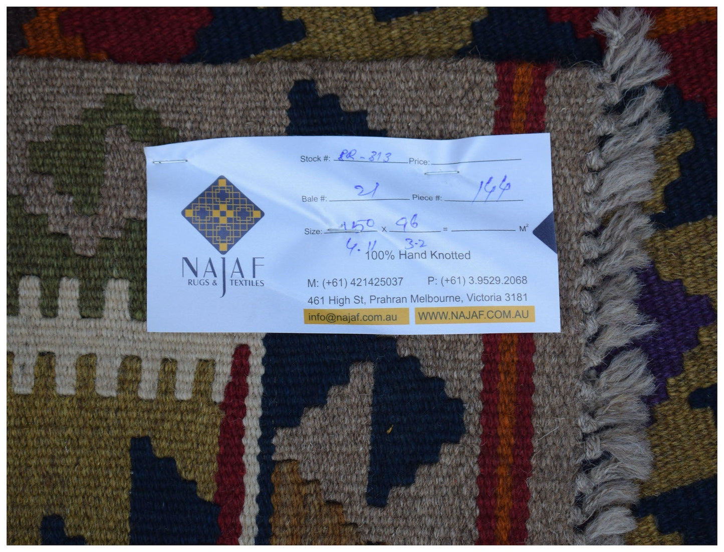A handwoven Afghan Maimana kilim featuring a geometric pattern in rich, earthy tones.