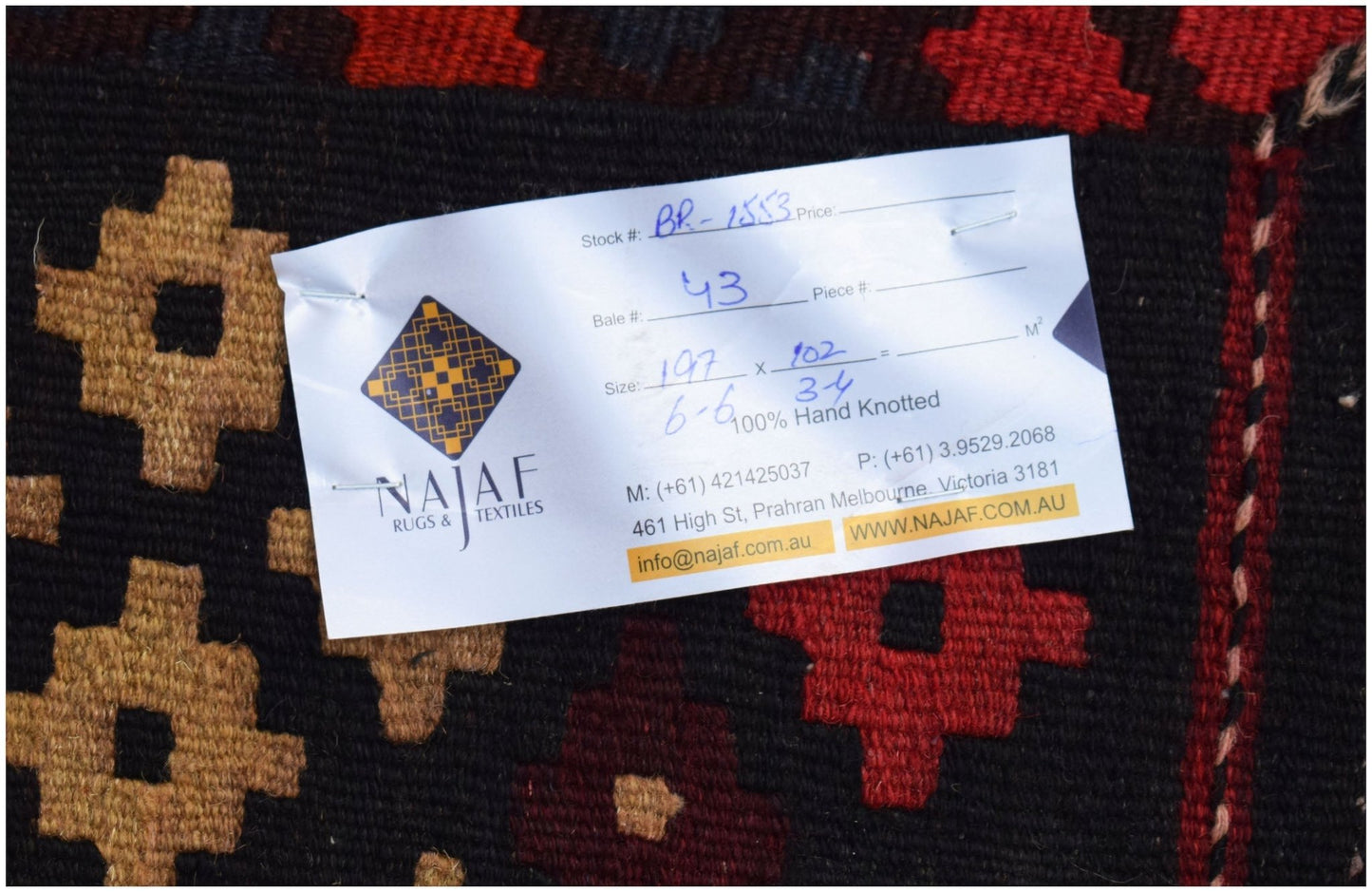 A handwoven Afghan Maimana kilim featuring a geometric pattern in red, black, and tan wool.