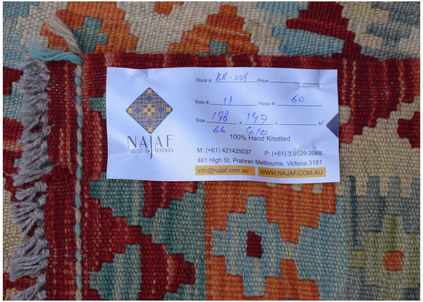 A handwoven Afghan Maimana kilim featuring a geometric pattern in red, orange, and blue tones.