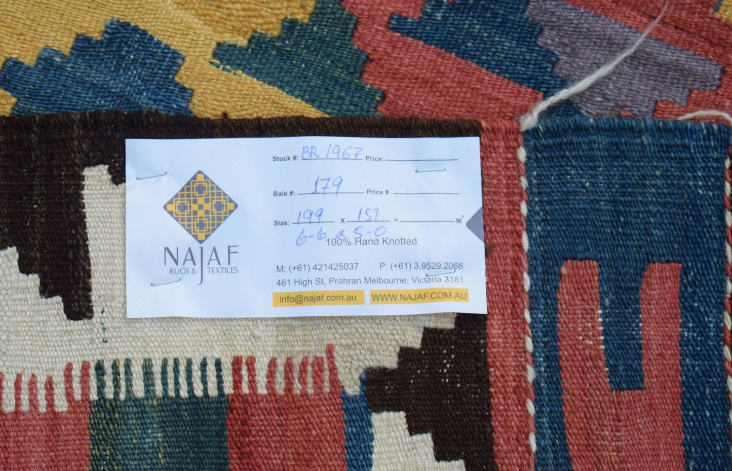 A handwoven Afghan Maimana kilim featuring a geometric pattern in red, blue, and yellow wool.