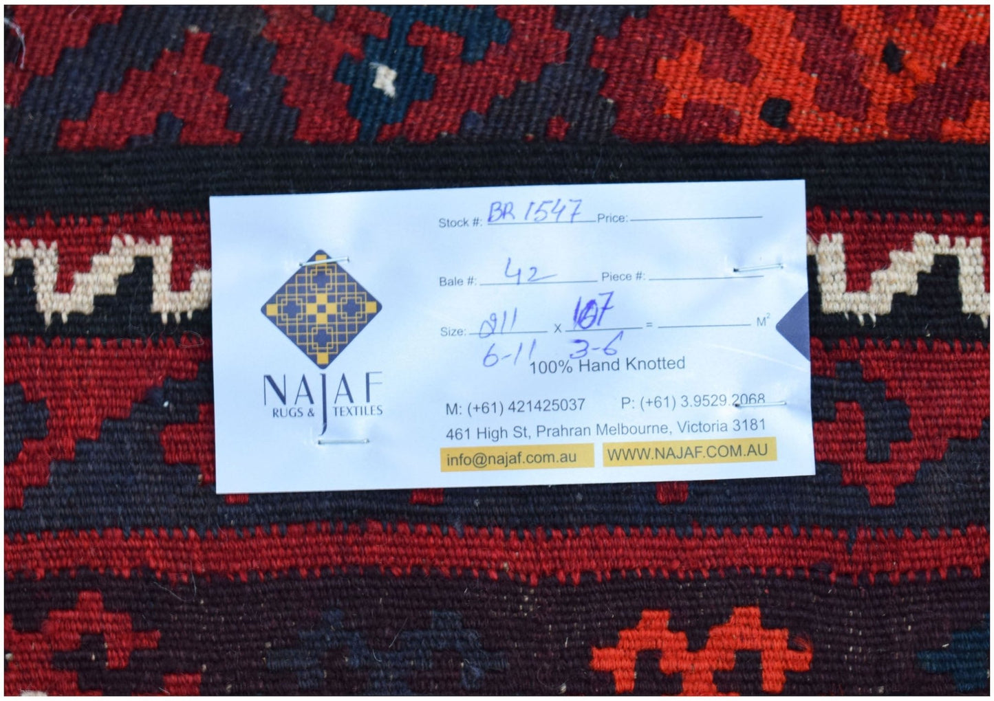 A handwoven Afghan Maimana kilim featuring a geometric pattern in shades of red, black, and cream.