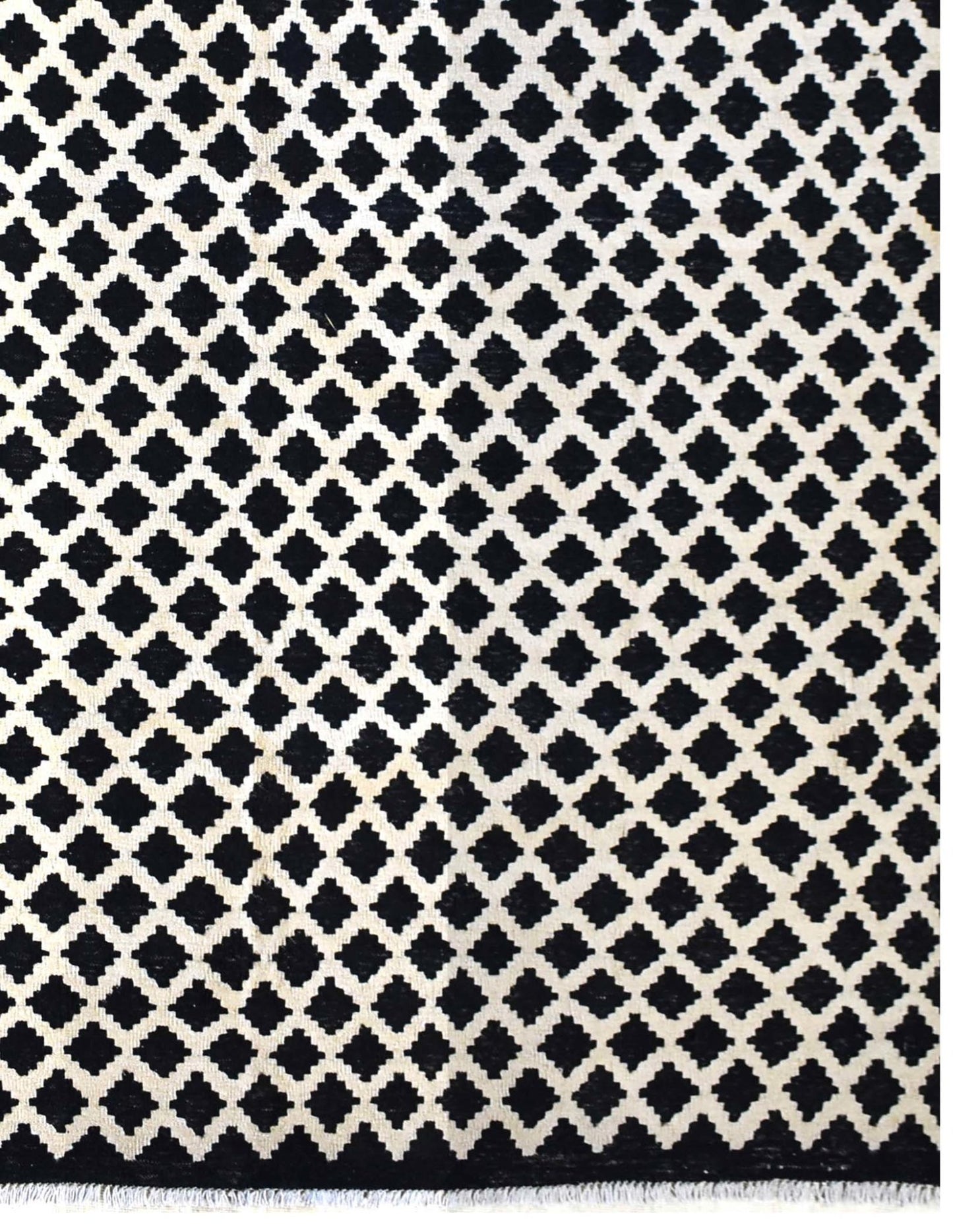 Handmade Afghan Maimana kilim rug featuring a repeating black and white geometric pattern.