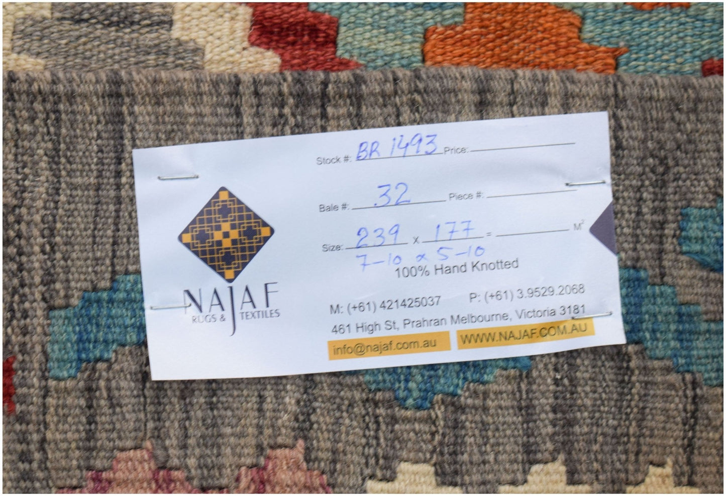 A handwoven Afghan Maimana kilim featuring a geometric pattern in vibrant, multi-colored wool.