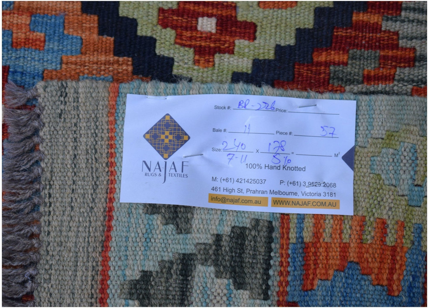 A handwoven Afghan Maimana kilim featuring a vibrant geometric pattern in wool.