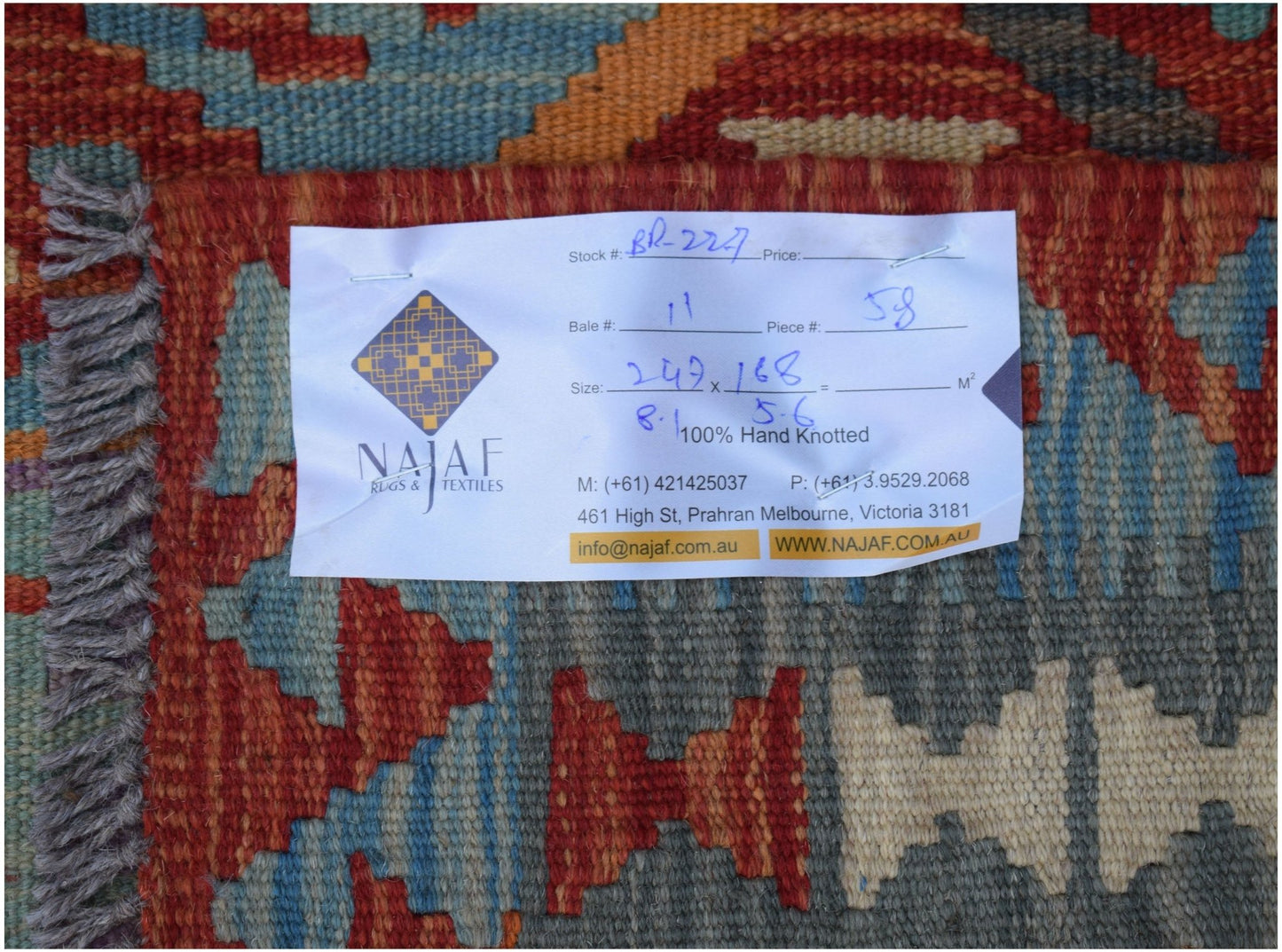 A handwoven Afghan Maimana Kilim featuring a geometric pattern in rich red, blue, and grey tones.