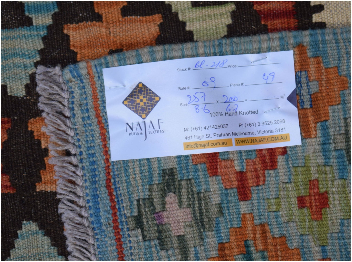 A handwoven Afghan Maimana kilim featuring a colorful geometric pattern and a flatweave texture.