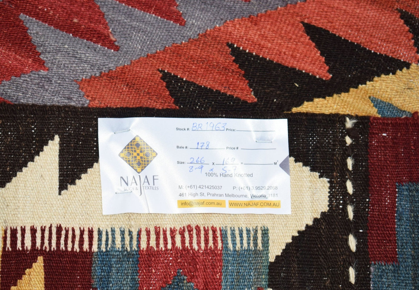 A handmade Afghan Maimana kilim featuring a geometric pattern in red, blue, and yellow tones.