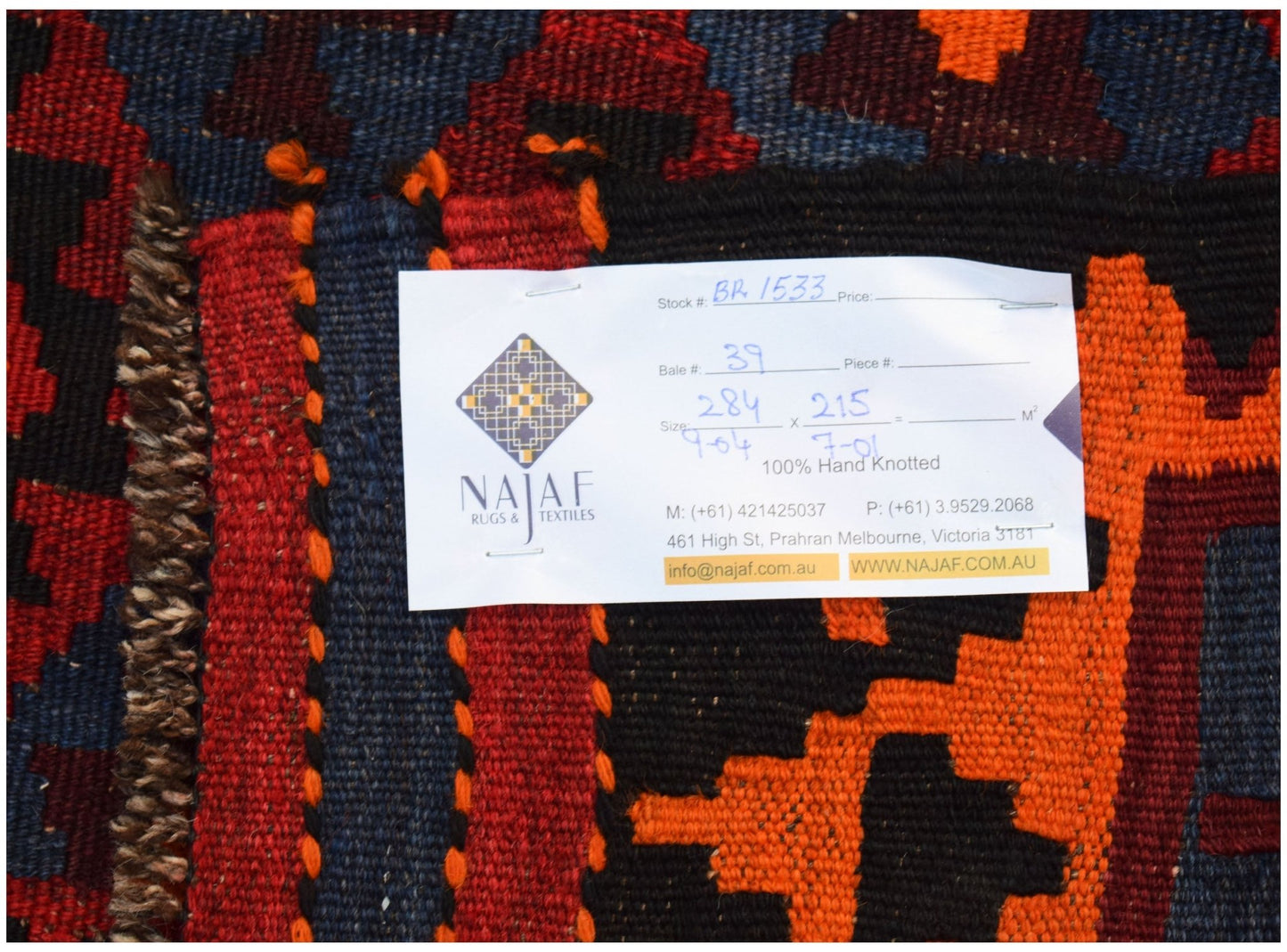 A handmade Afghan Maimana kilim featuring a geometric pattern in red, orange, black, and blue.